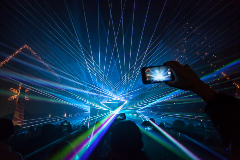 Lasershow von Ländle Event. Jemand fotografiert die Lasershow.
