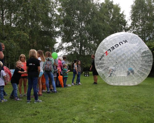 Riesen Zorb Ball mit Kindern von Ländle Event. Kinder rennen im Ball. am Dornbirner Spielefest